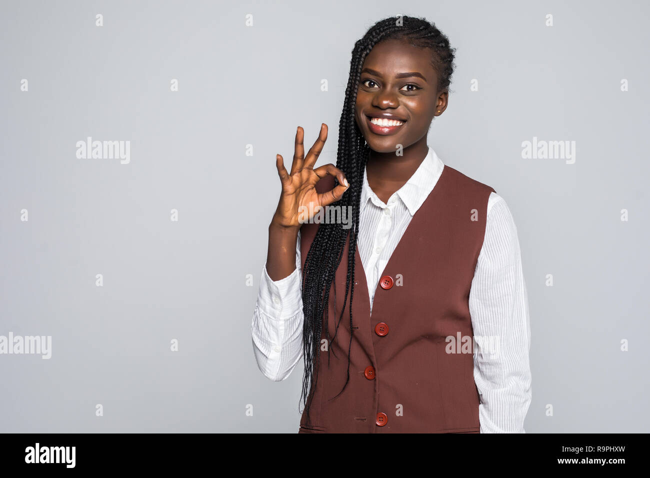 Portrait of afro american woman gesturing ok sign with fingers looking ...