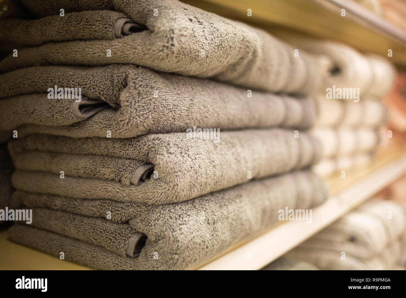 Folded grey towels on the shelf clean after loundry Stock Photo