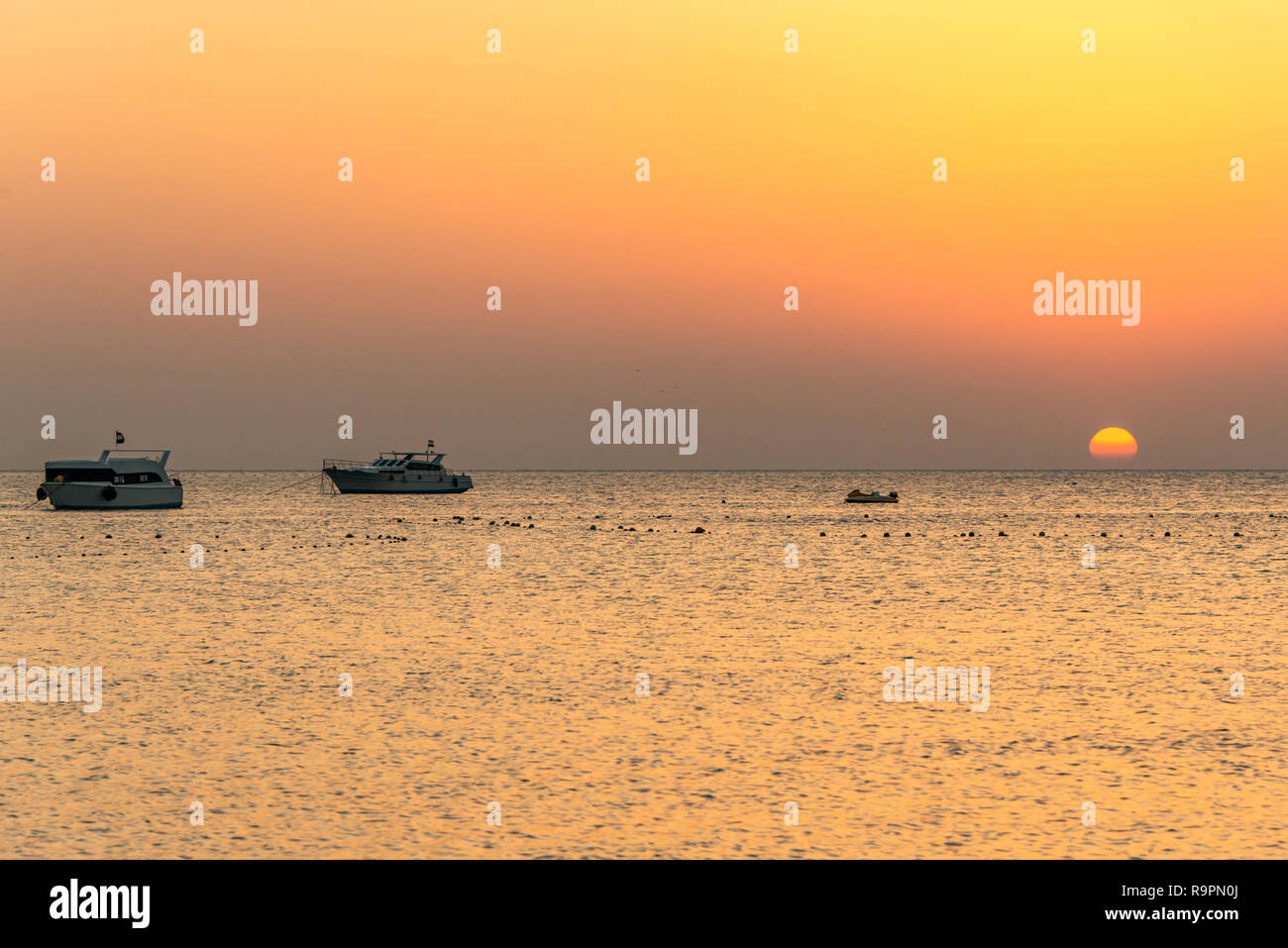 boat silhouetts on the shores of the red sea at sunset in Makadi Bay ...