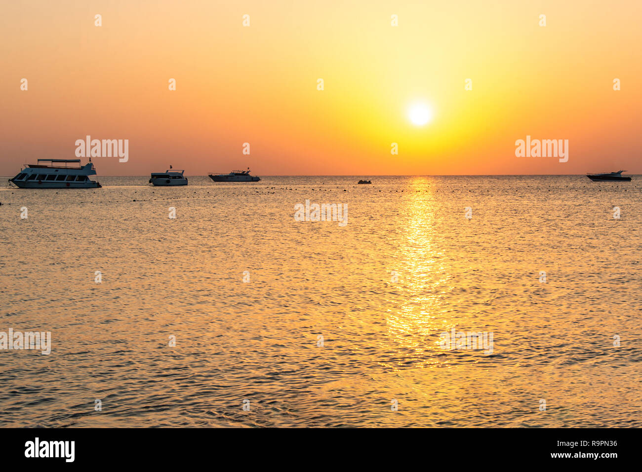 boat silhouetts on the shores of the red sea at sunset in Makadi Bay ...