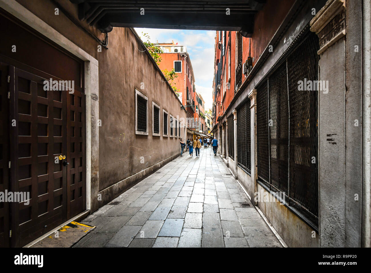 Venice, Italy - September 18 2018: Tourists walk past cafes and shops along the narrow streets of Venice, Italy Stock Photo