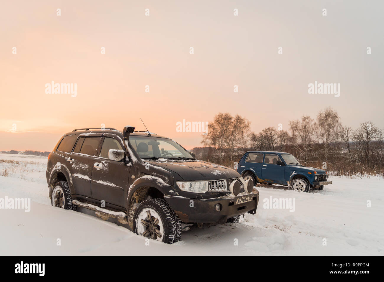 Moscow, Russia - December 25, 2018: Off-road cars Mitsubishi Pajero Sport (Montero) and Lada Niva 4x4 (VAZ 2121 / 21214)  parked on the snow field. Stock Photo