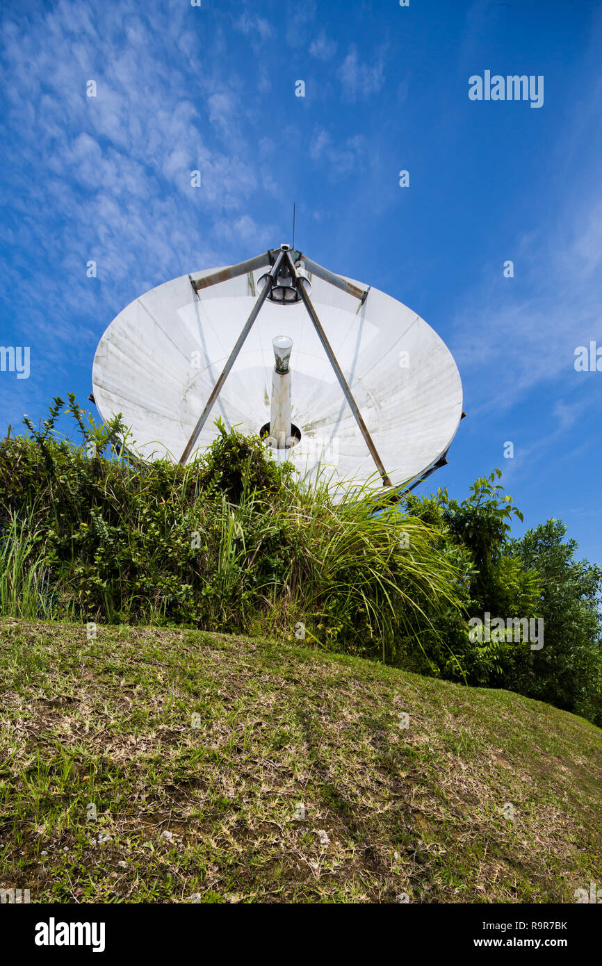 A small satellite dish against a blue sky back drop. Singapore Stock Photo