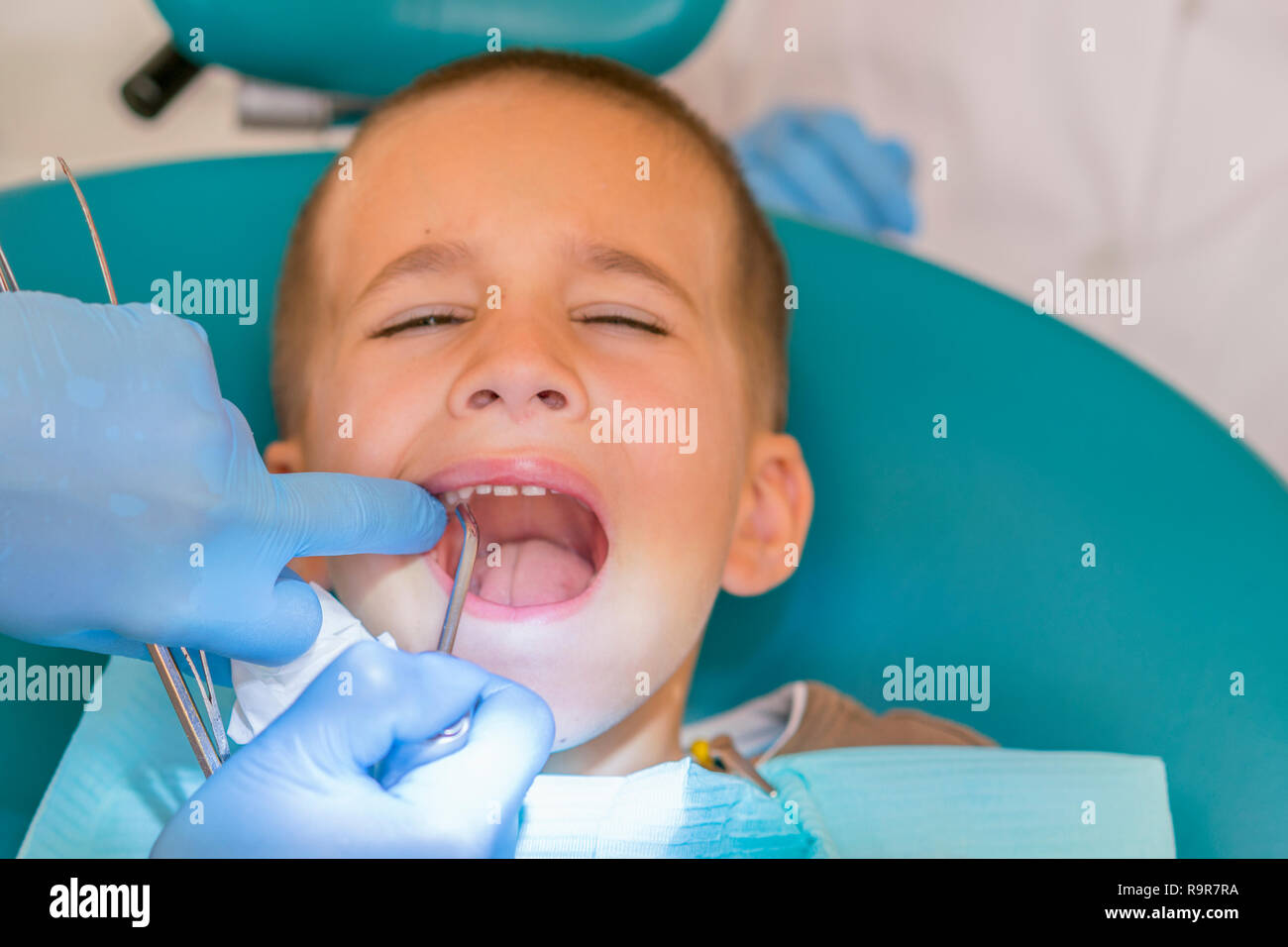 Dentist is treating a boy's teeth. Dentist examining boy's teeth in