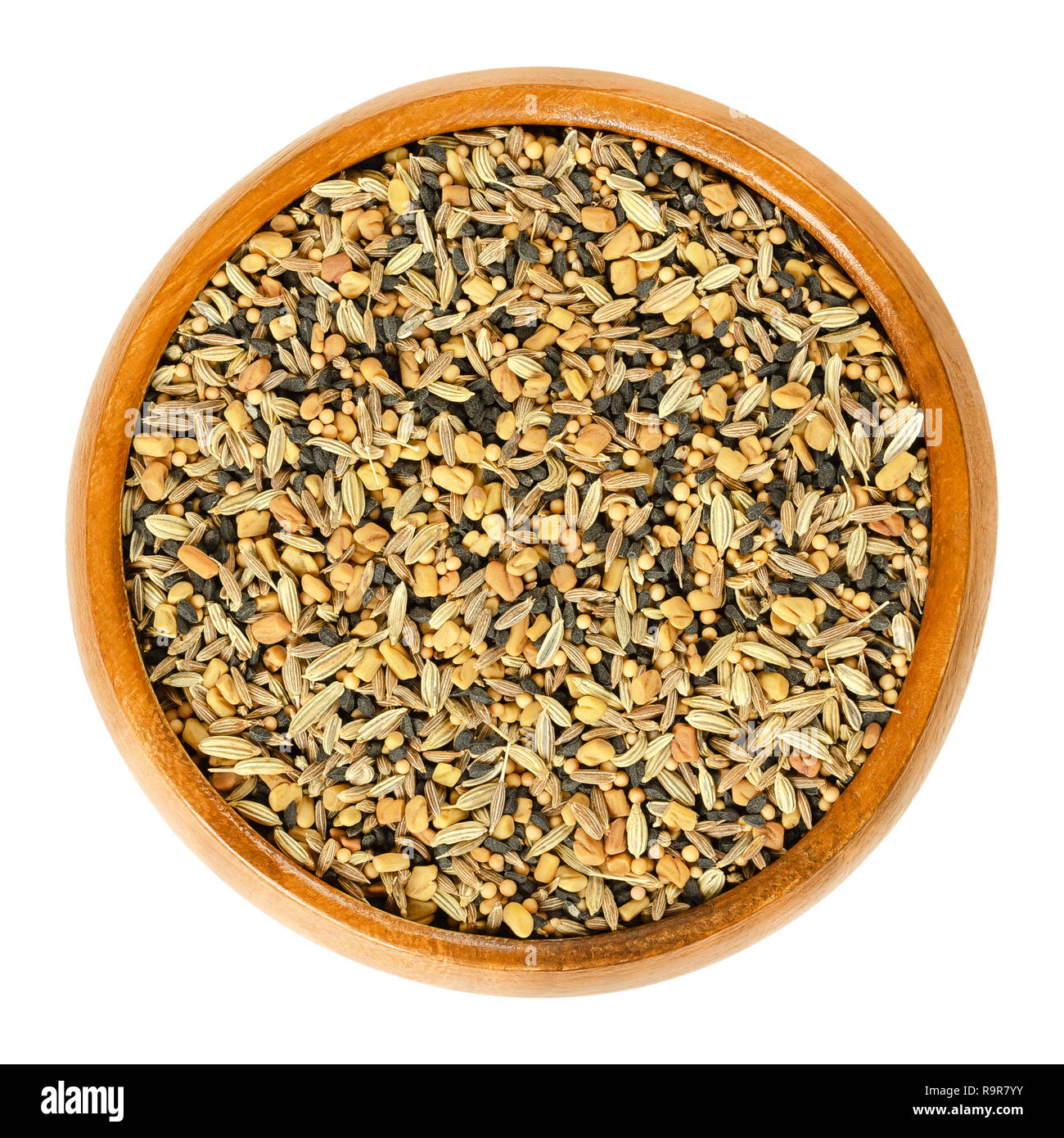 Panch phoron, whole spice blend in wooden bowl. Mix of five spices. Fenugreek, nigella, cumin, mustard and fennel seeds. Isolated macro food photo. Stock Photo