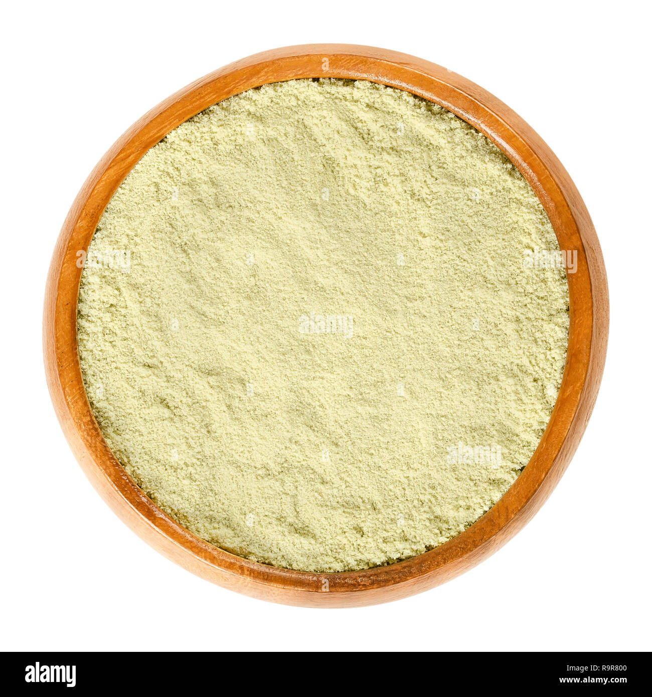 Wasabi powder in wooden bowl. Dried ground rhizomes of Japanese horseradish, Eutrema japonicum or Wasabia japonica. Slightly green. Sushi condiment. Stock Photo