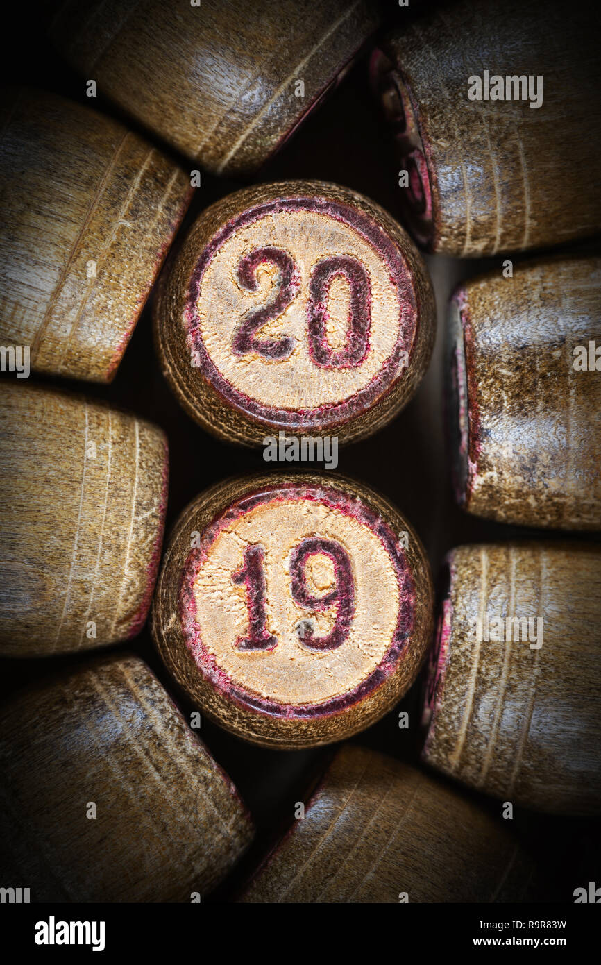 Vintage wooden lotto kegs with two numbers 20 and 19 as symbol of Close-up top view of 2019 New Year inscription in circle with pink trim. 2019 year. Stock Photo