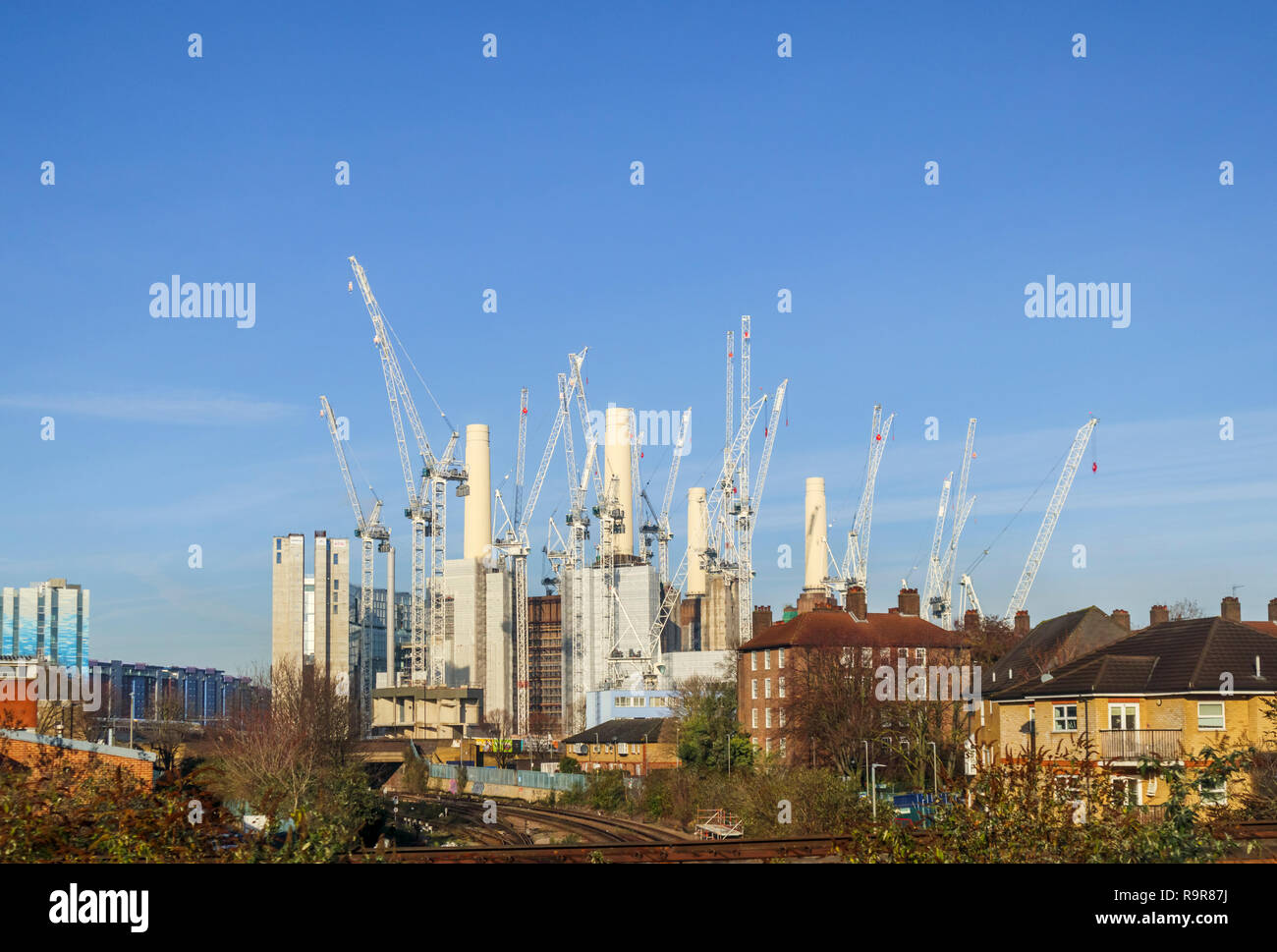 White tower cranes surround the iconic decommissioned Battersea Power Station being redeveloped for mixed uses and high class luxury apartments Stock Photo