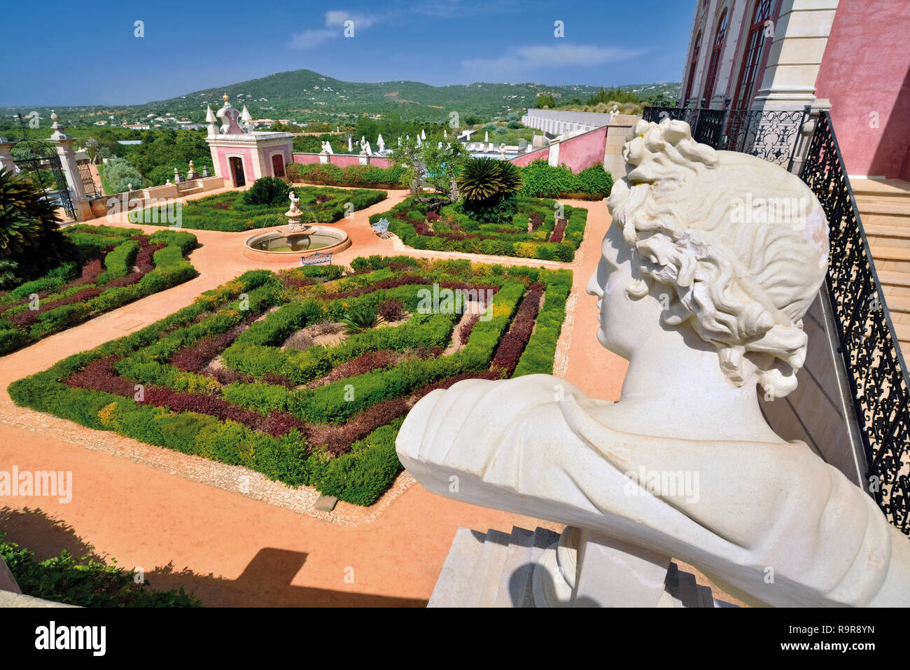 Roman bust and view to rokoko garden from pink and white painted palace Stock Photo