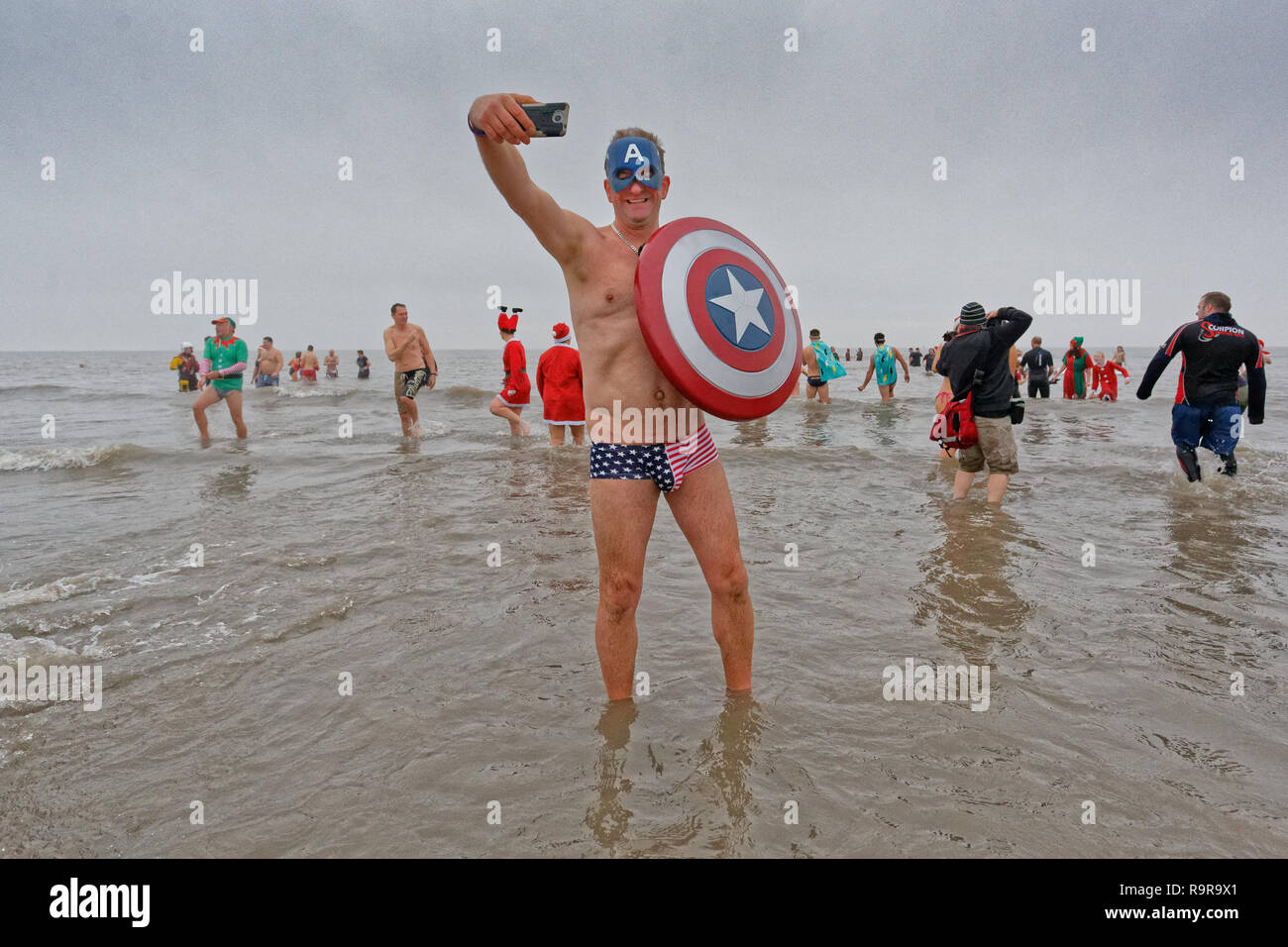 Pictured: A man dressed as Captain America takes a selfie. Tuesday 25 December 2018 Re: Hundreds of people take part in this year's Porthcawl Christma Stock Photo