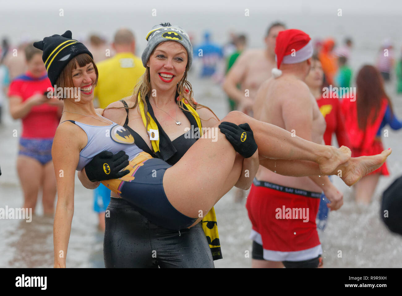 Pictured: Two women in Batman costumes. Tuesday 25 December 2018 Re: Hundreds of people take part in this year's Porthcawl Christmas Swim in south Wal Stock Photo