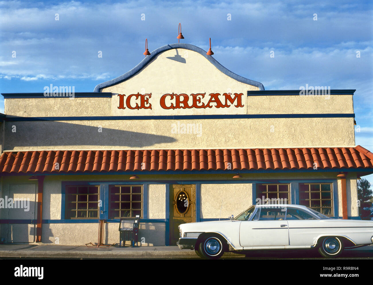 Ice cream shop with parked American vintage car and blue sky Stock