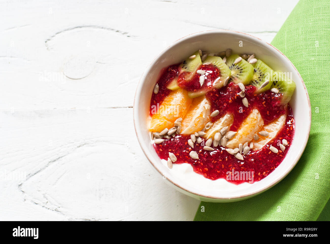 Dessert with sour cream, orange, kiwi, raspberry jam and seeds. Healthy