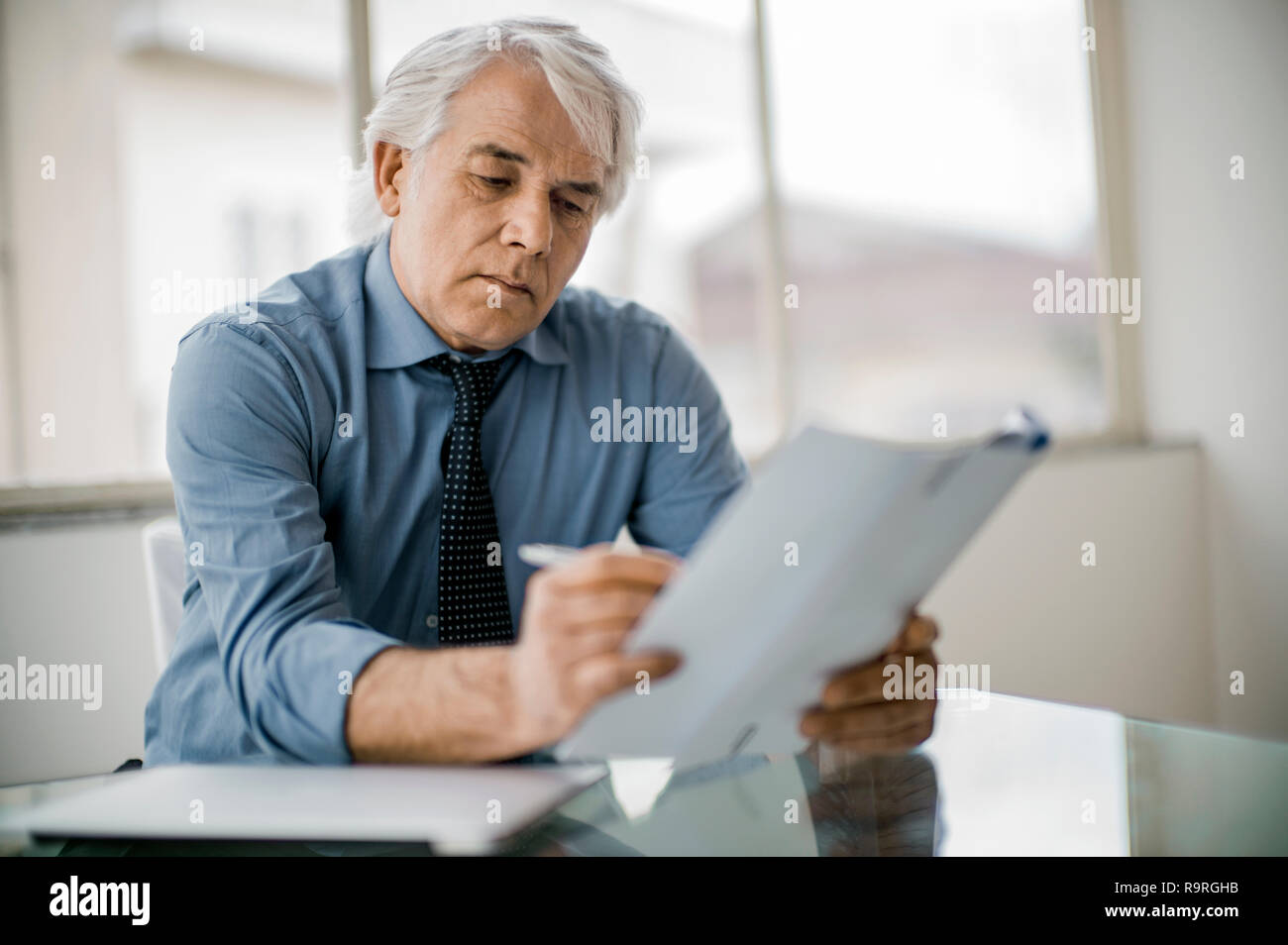 Focused businessman working in a corporate board room. Stock Photo