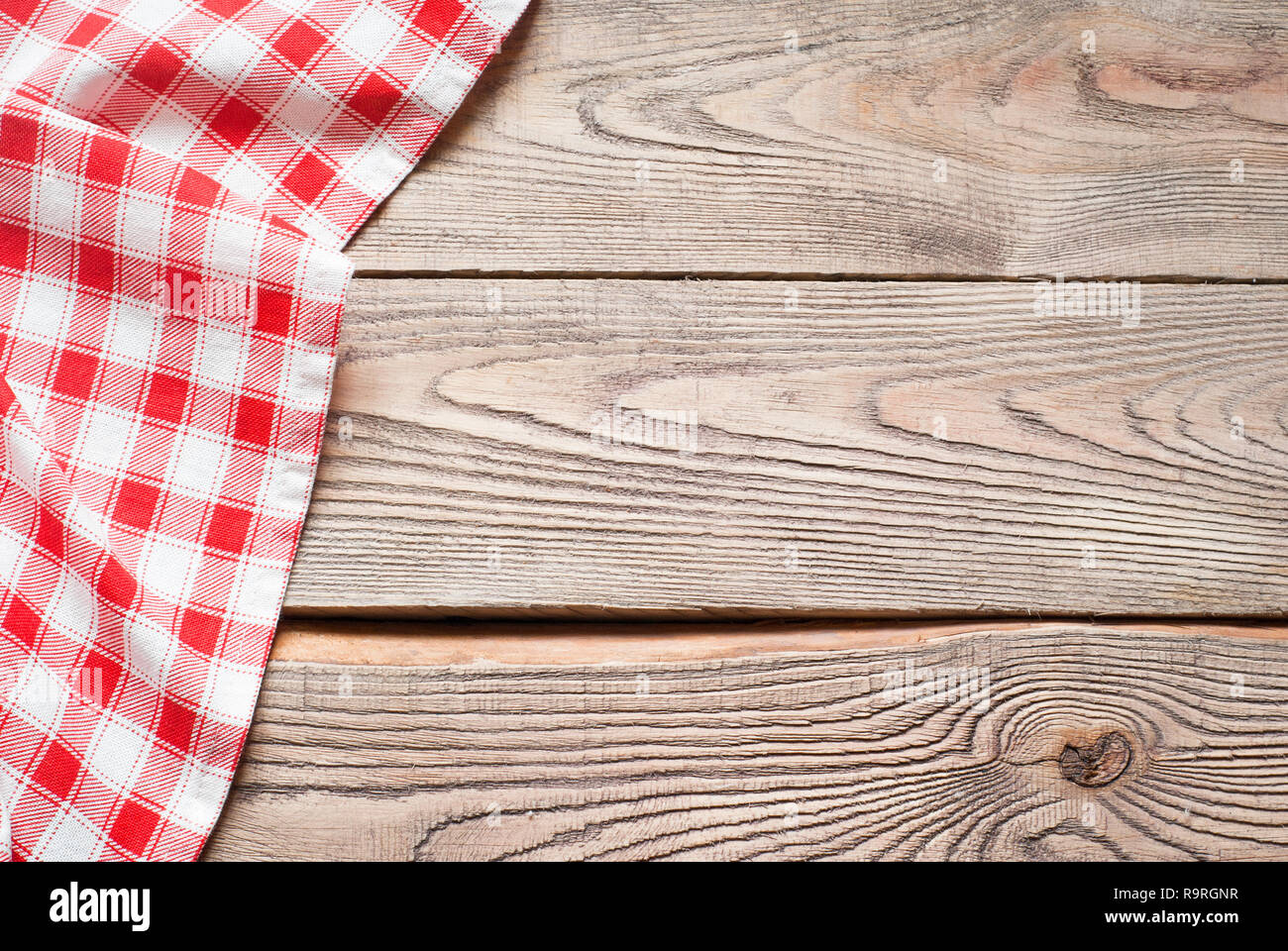 Red towel over wooden kitchen table. View from above with copy space ...