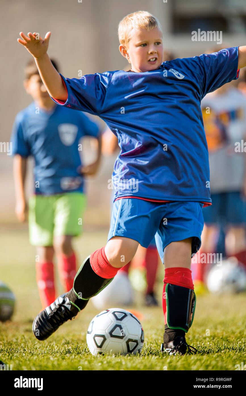 Young boy kicking a ball during a soccer game. Stock Photo