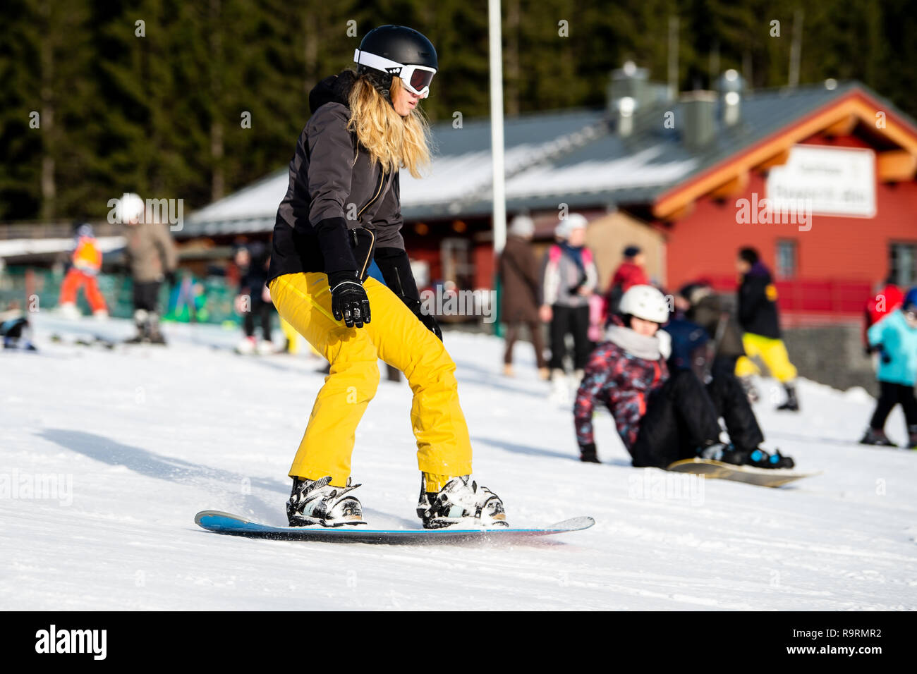 Braunlage, Germany. 27th Dec, 2018. A winter sportswoman rides a snowboard  down a hill on a witch ride. On the witch ride at Wurmberg in the Harz, the  winter sports season has
