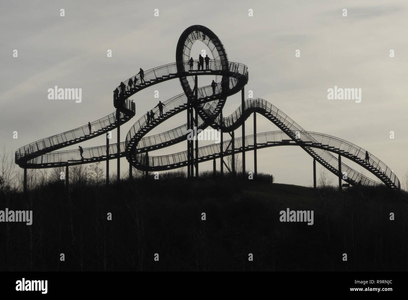 December 27, 2018 - Duisburg, North Rhine-Westphalia, Germany - People can be seen walking on the 'Tiger and Turtle ''“ Magic Mountain' art installation in Angerpark, Duisburg, Germany. Designed by ULRICH GENTH and HEIKE MUTTER in 2011, it is 21 meters tall, made out of tin, zinc and steel. It resembles a roller coaster but is completely walkable, except for the loop. Credit: Jan Scheunert/ZUMA Wire/Alamy Live News Stock Photo