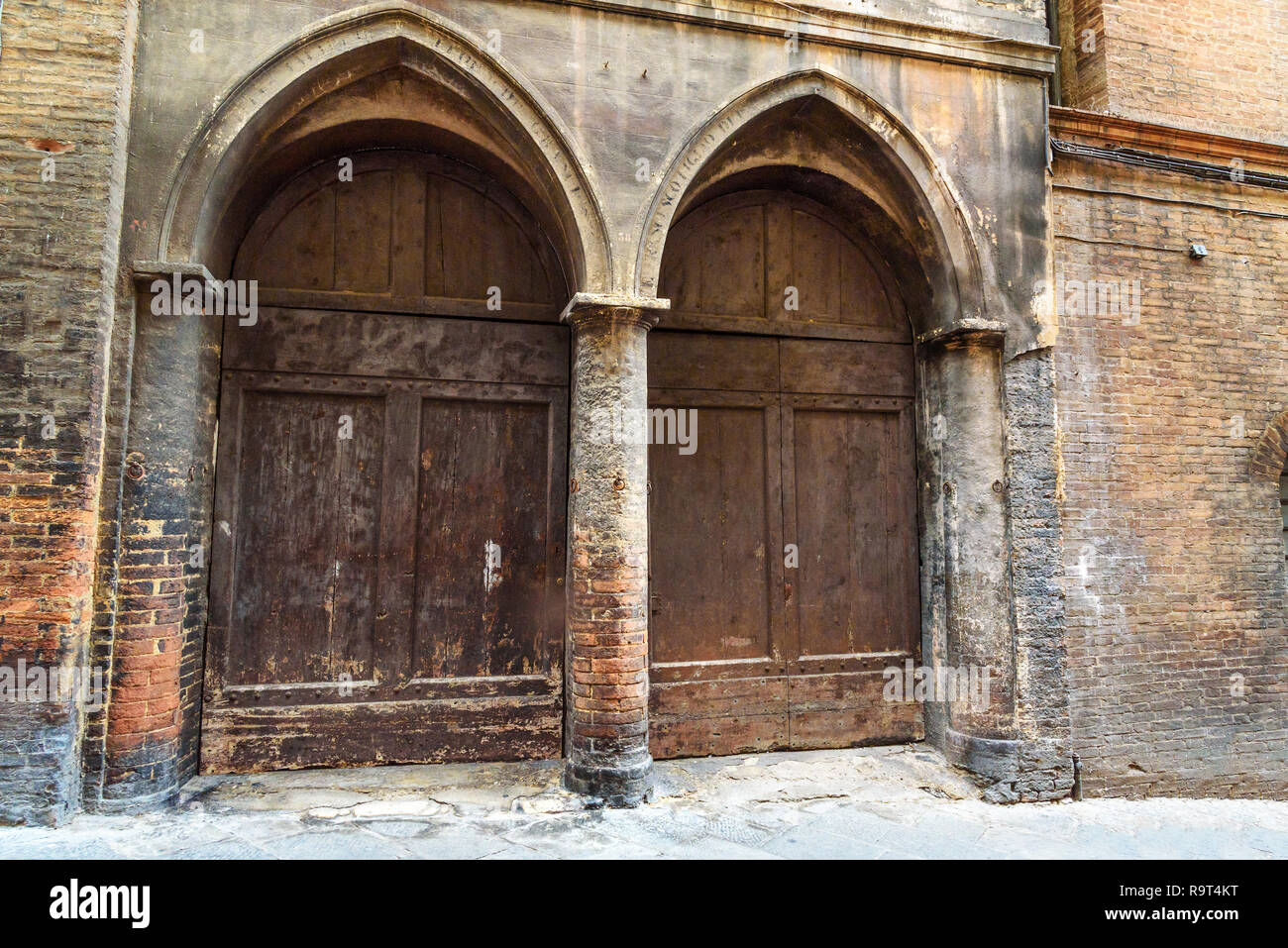 Traditional wooden arch door on medieval brick building in Siena. Italy  Stock Photo - Alamy