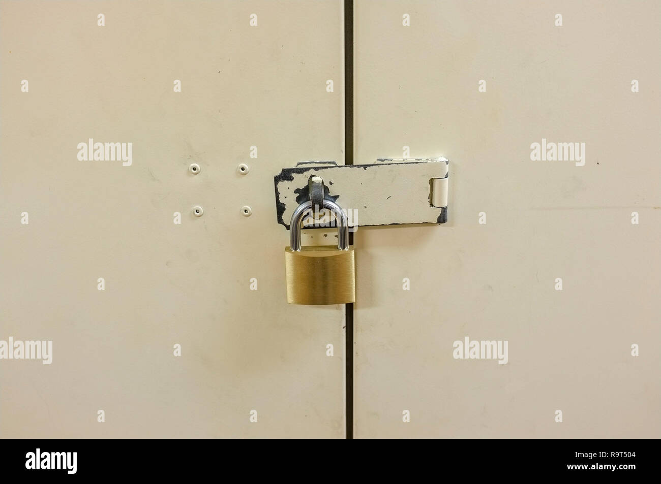Padlock on closed metal door. Stock Photo