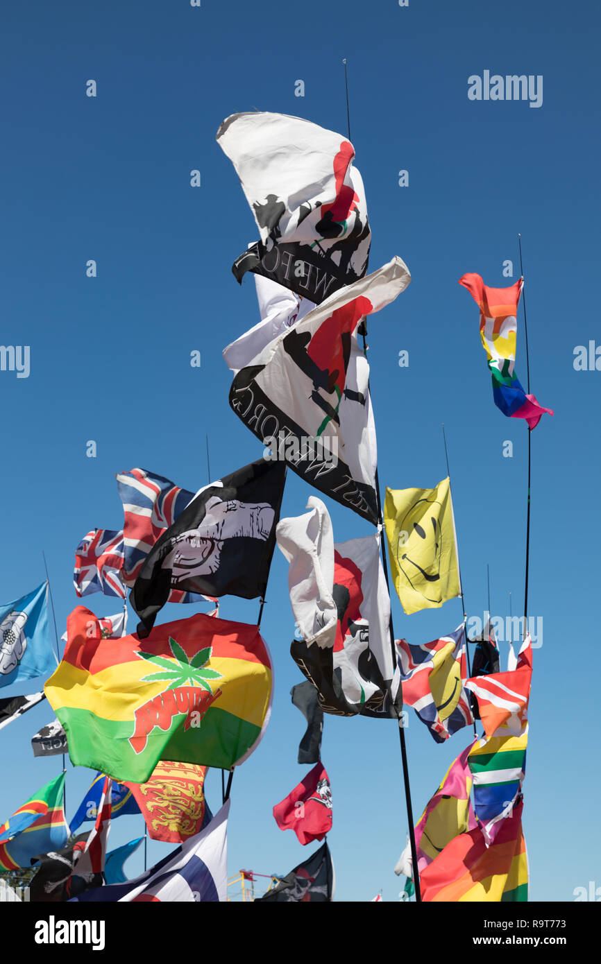 Hollowell, Northamptonshire, UK. Colourful flags and pennants, attached to thin poles, are fluttering in the wind under a clear blue sky. Stock Photo