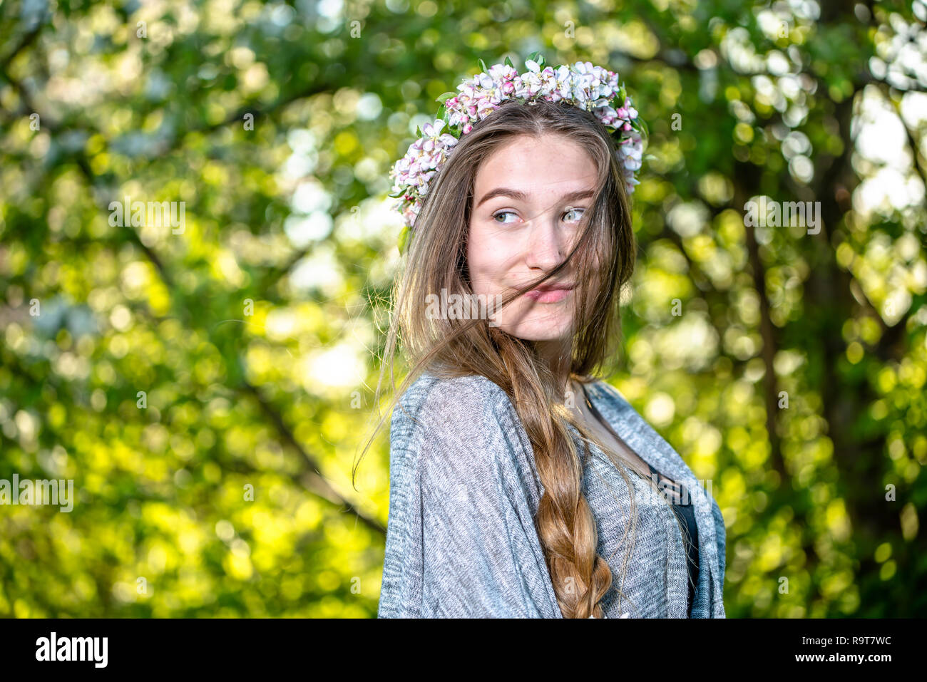 Portrait of a girl in nature. Young woman with long braid and wreath of ...