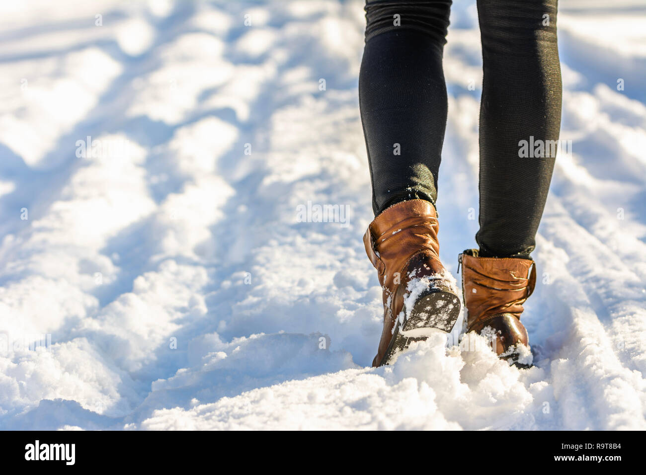 Female feet in boots and leggings, winter walking in snow Stock