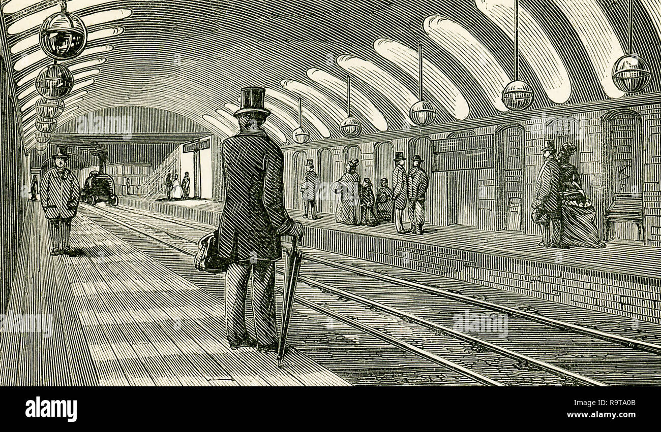 This illustration dates to the 1870s and shows the Gower Street Train Station in England in the 1870s - a stop for the Metropolitan railway. The booking offices for the up line are on one side of the road, and those for the down line on the other. This view represents the interior of the Gower Street Station. In each the platforms are 325 ft. long and 10 ft. broad, and the stations are lighted by lateral openings through the springing of the arch which forms the roof. This arch is a portion of a circle of 32 ft. radius, with a span of 45 ft. and a rise of 9 ft. at the crown. The lateral openin Stock Photo