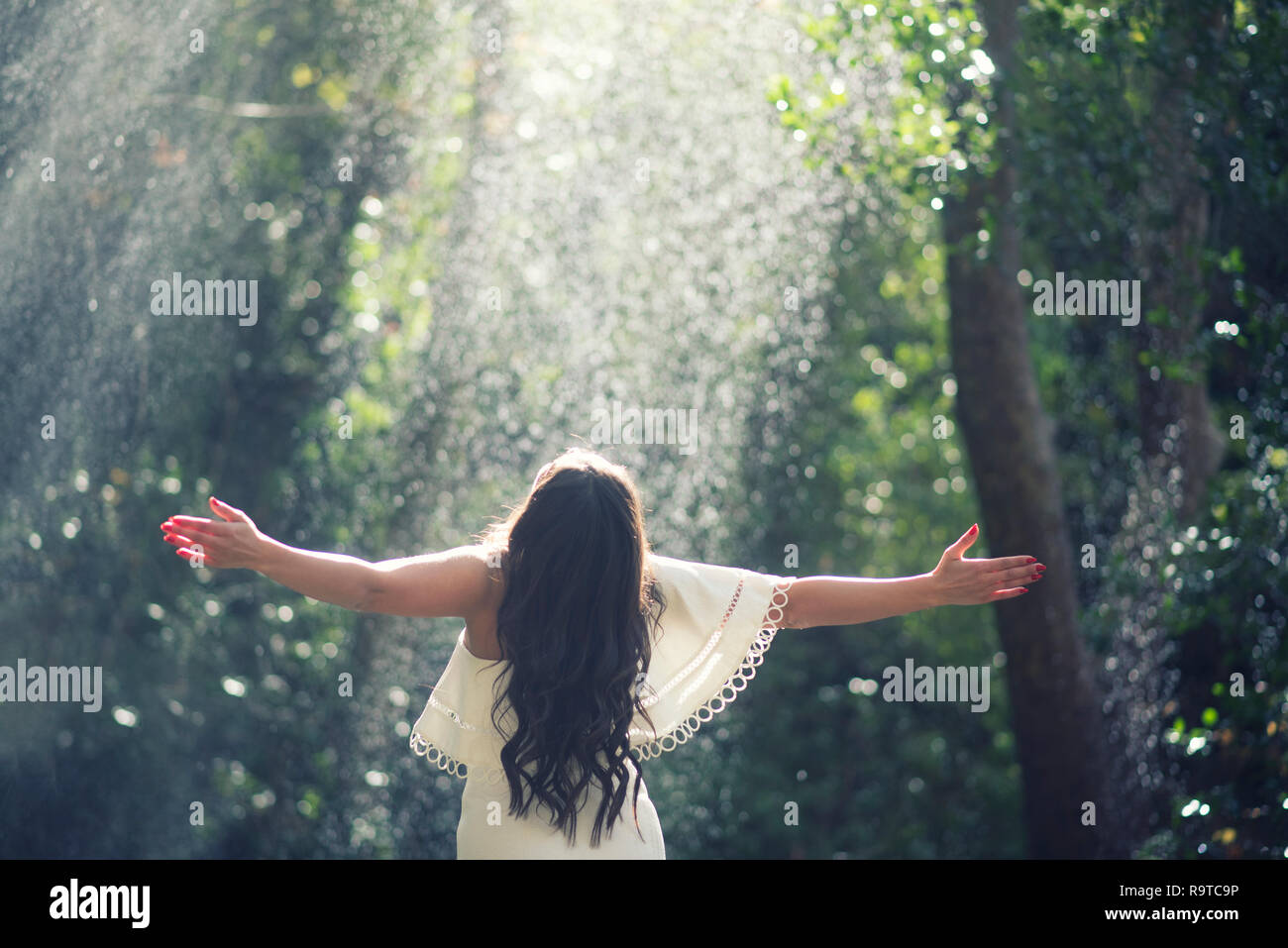 Rear view of a woman arms outstretched in the rain Stock Photo - Alamy