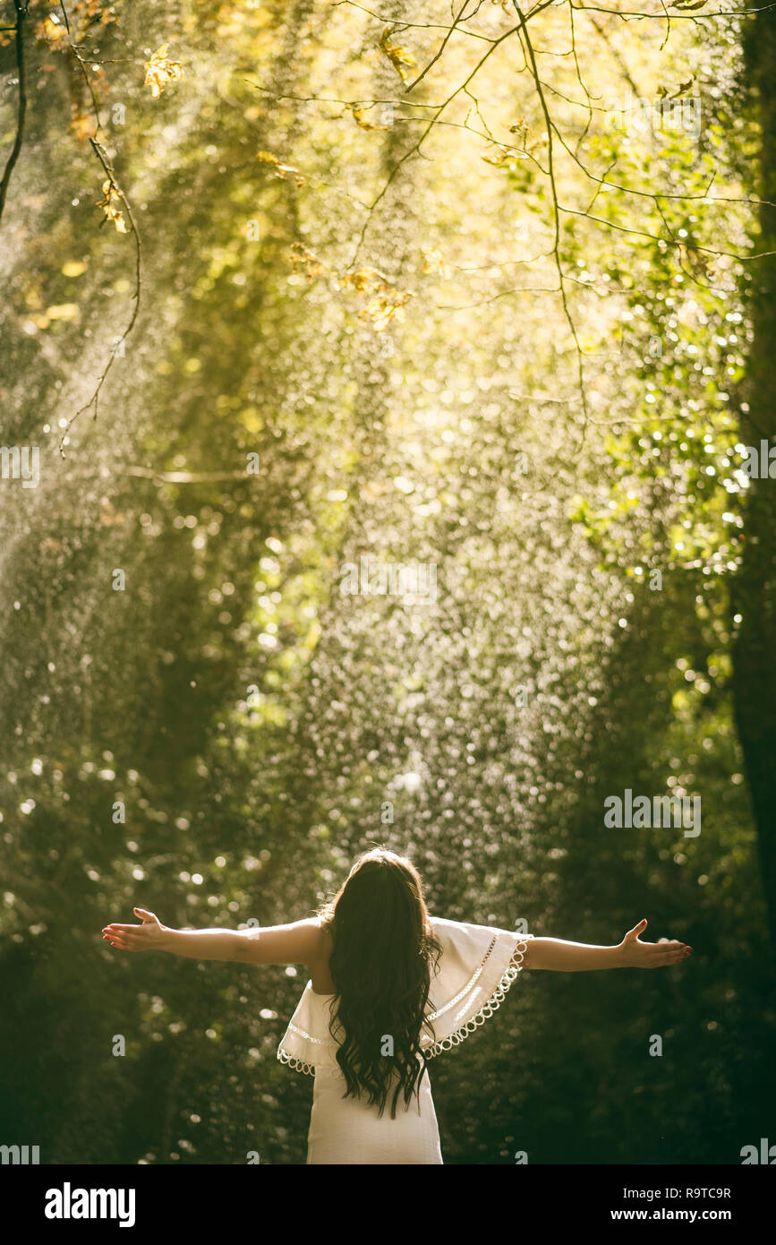 Rear view of a woman arms outstretched in the rain Stock Photo - Alamy