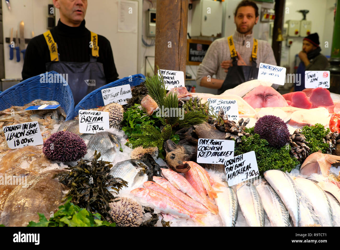 Fishmongers selling various fresh fish on Borough Market seafood stall in November Southwark South London England UK  KATHY DEWITT Stock Photo