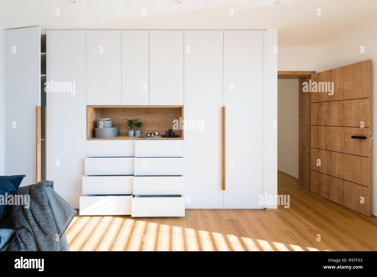 White Wooden Closet With Open Shelves In Bedroom Of Modern
