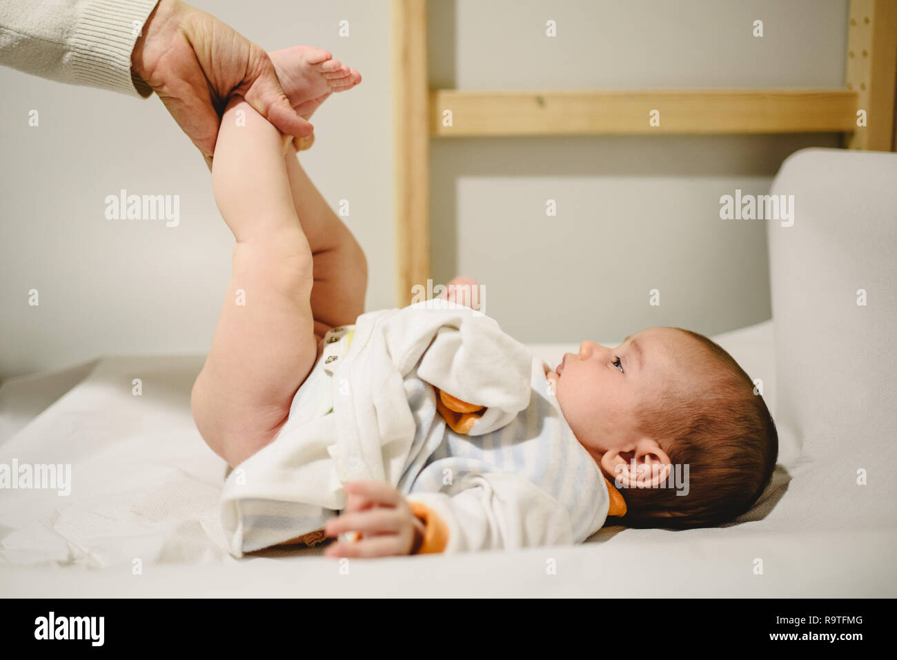 Mother changing diaper to baby, lifting her little legs Stock Photo Alamy