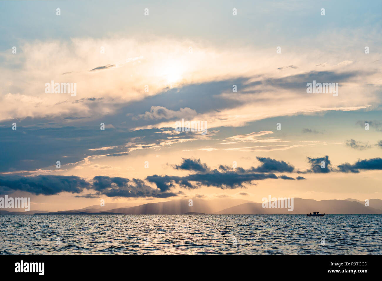 Beautiful sunset over sea with reflection in water, majestic clouds in ...