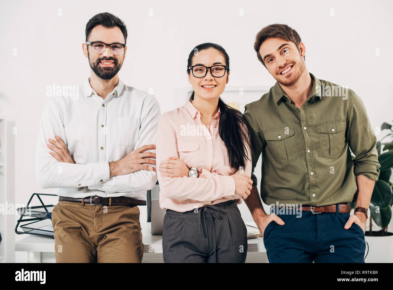 office managers with arms crossed smiling and looking at camera in ...