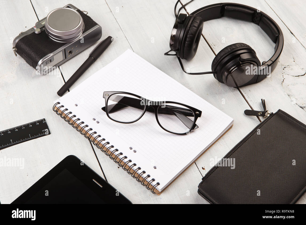 workplace with tablet pc, notepads, camera and pen Stock Photo