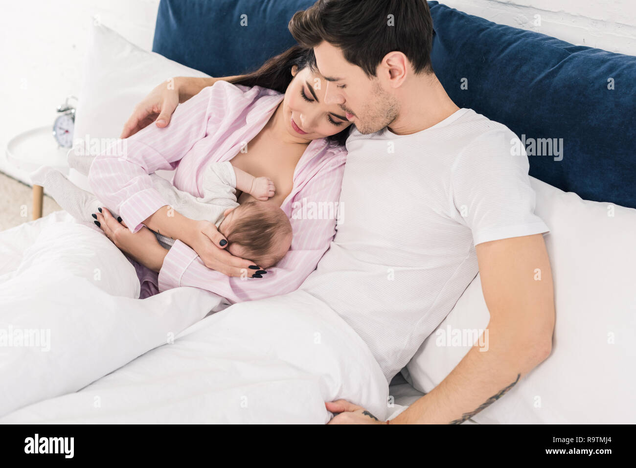 Mother giving milk to baby and husband deals