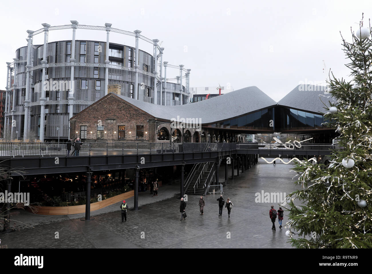 People and Christmas tree in Coal Drops Yard and view of Gasholders