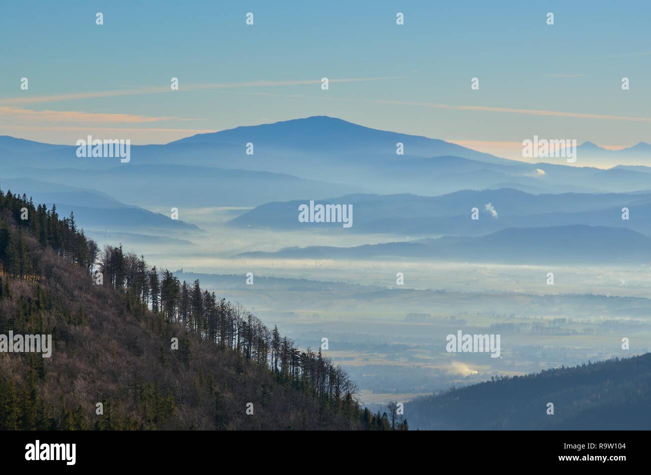 Beautiful morning autumnal mountain landscape. Mists in the valleys under the mountain tops. Stock Photo