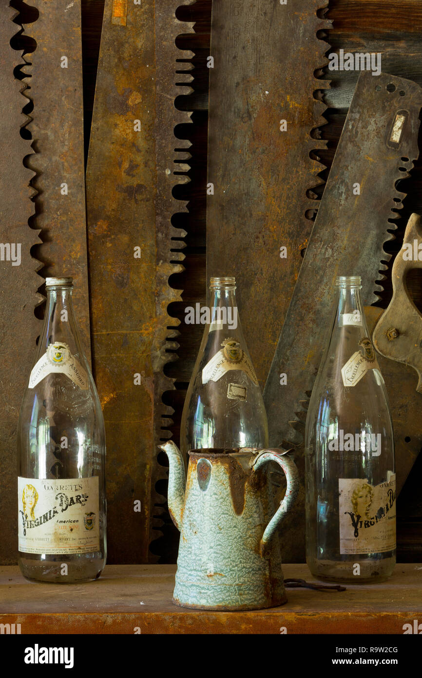 Rust and decay patterns of a saws with bottles and a coffee pot too, in a Montana ghost town. USA Stock Photo