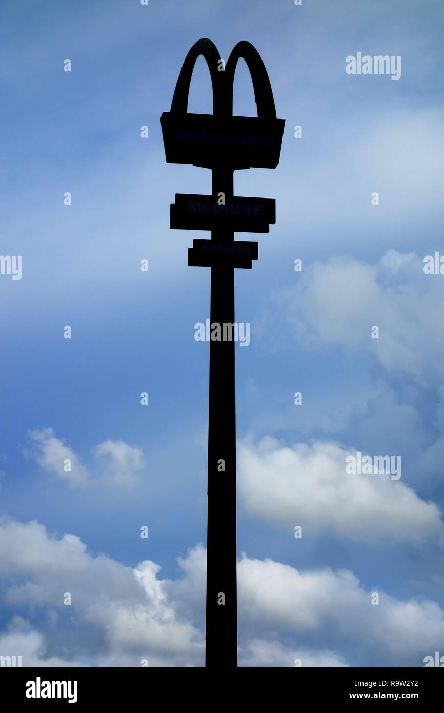 Aprilia, Italy - Aug 2015: Silhouette of Mac Donald signpost against blue sky Stock Photo
