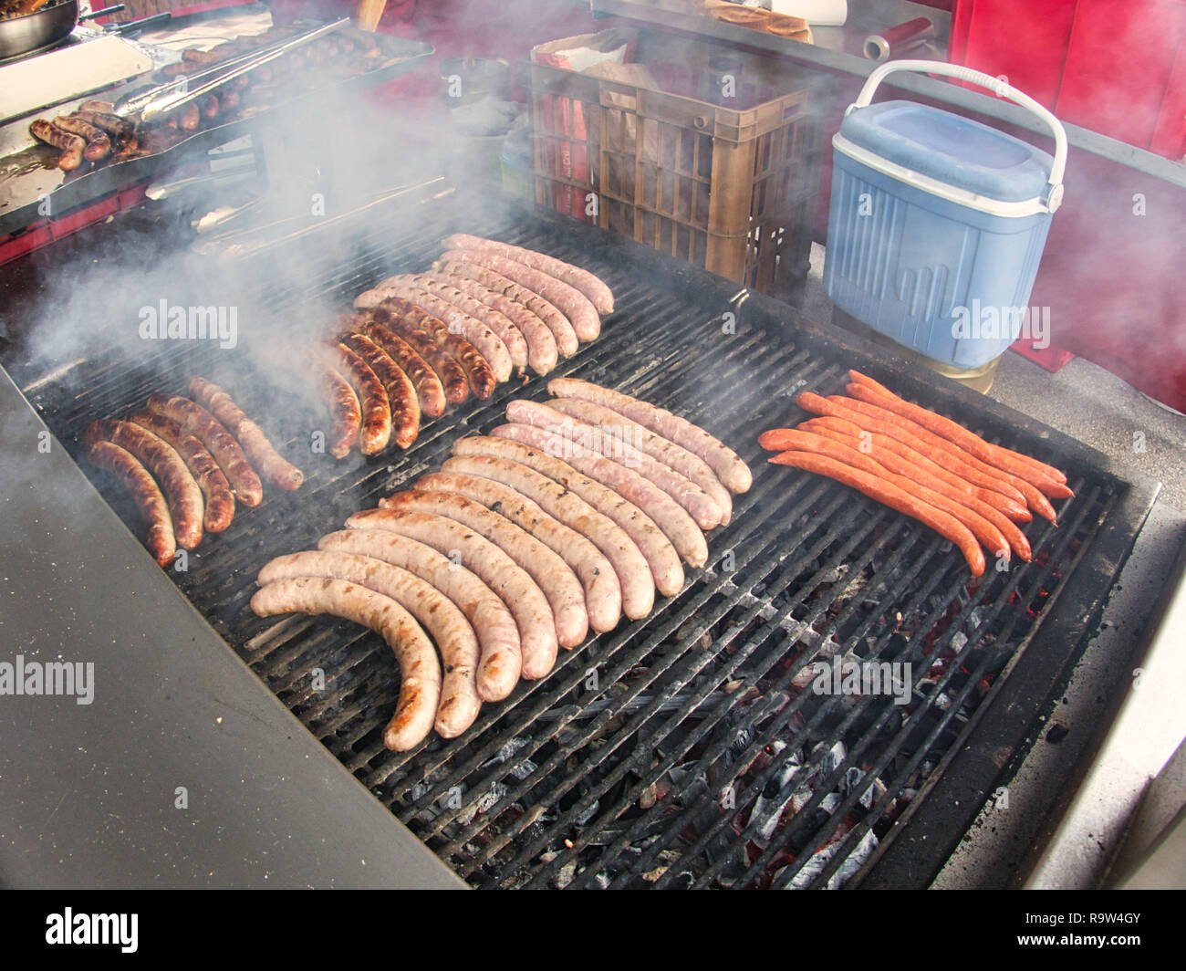 Frying fresh meat barbecue sausages merguez brats, BBQ picnic sandwich store outdoor on big grill Stock Photo