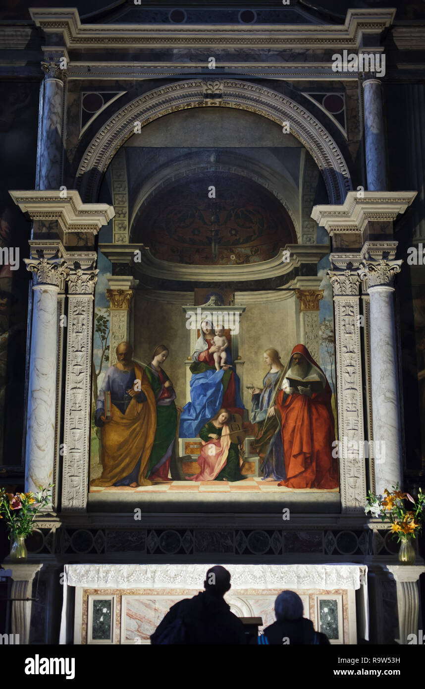 Visitors in front of San Zaccaria Altarpiece by Italian Renaissance painter Giovanni Bellini (1505) located in the Church of San Zaccaria (Chiesa di San Zaccaria) in Venice, Italy. Stock Photo