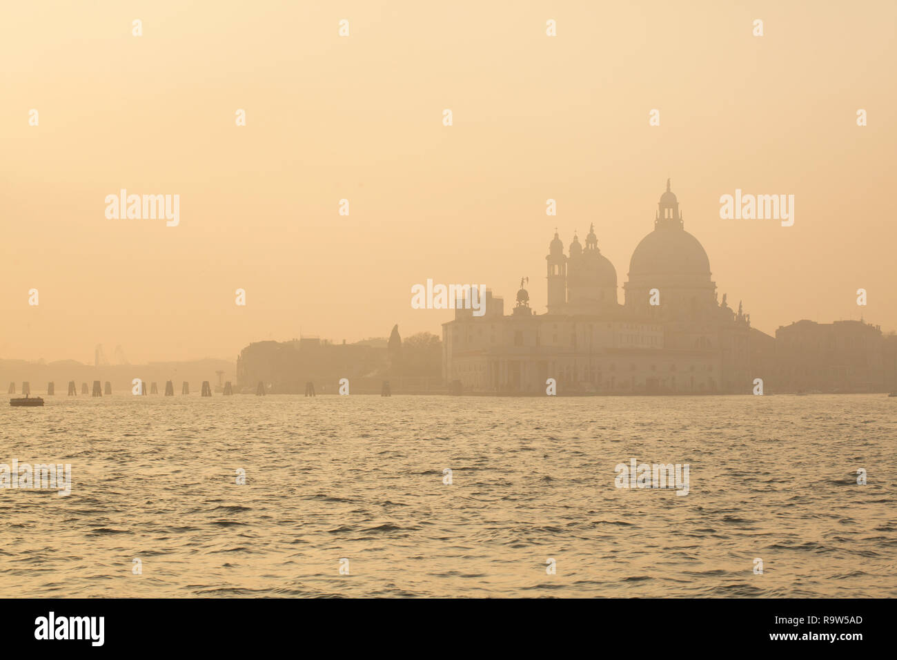 Sunset over the Basilica of Santa Maria della Salute (Basilica di Santa Maria della Salute) and the Venetian Lagoon (Laguna di Venezia) in Venice, Italy. Stock Photo