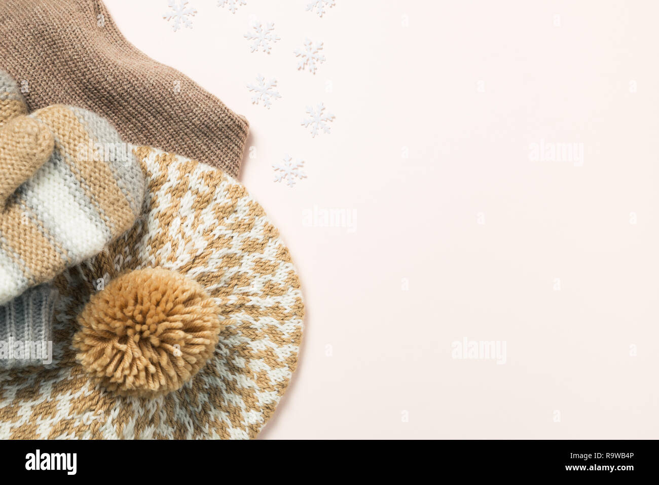 Warm knitted hat, gloves on pink background. Winter season concept Stock Photo