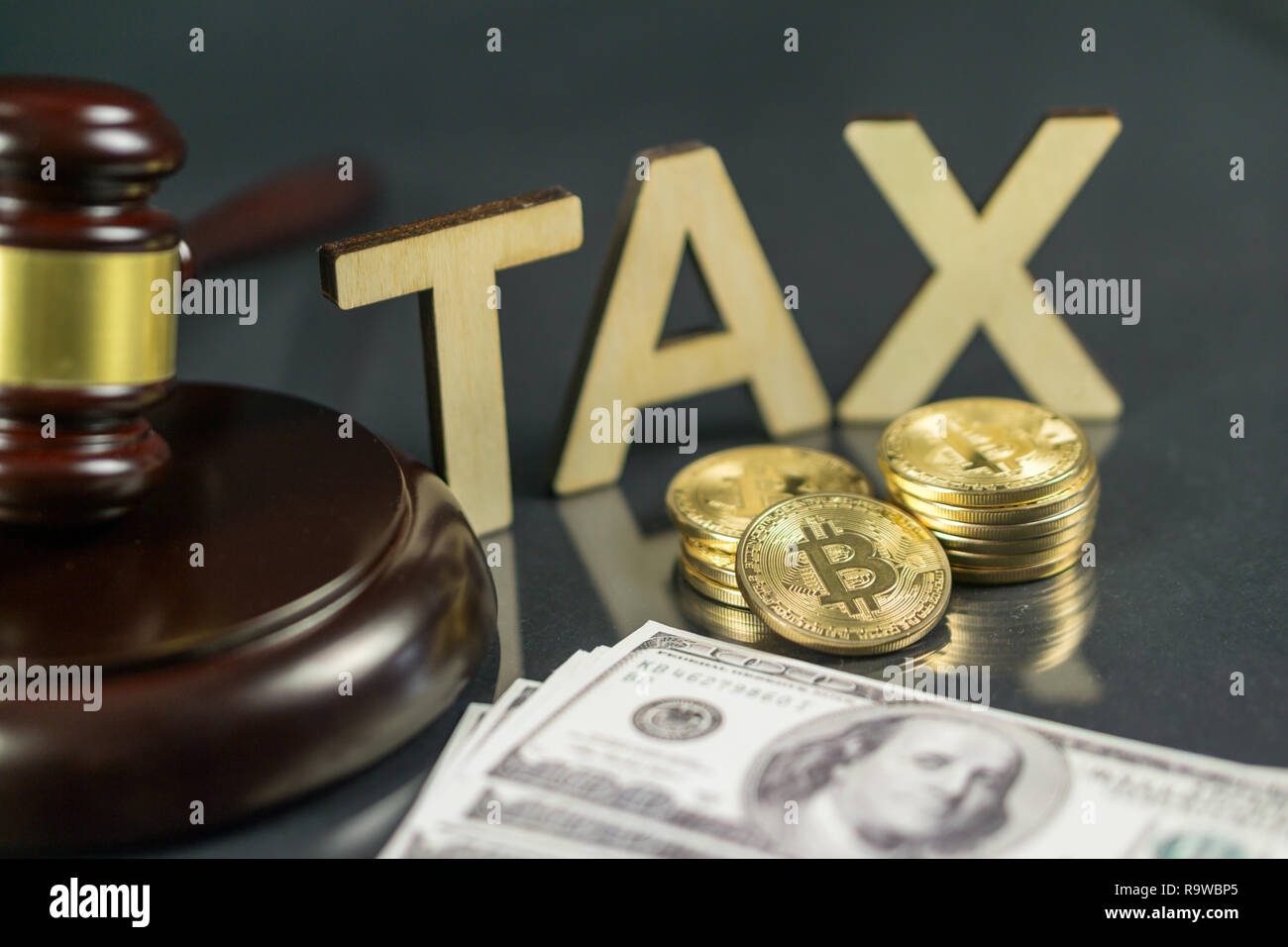 Gavel and cryptocurrency with hundred dollar bills around it. Government regulation concept. Tax payment Stock Photo