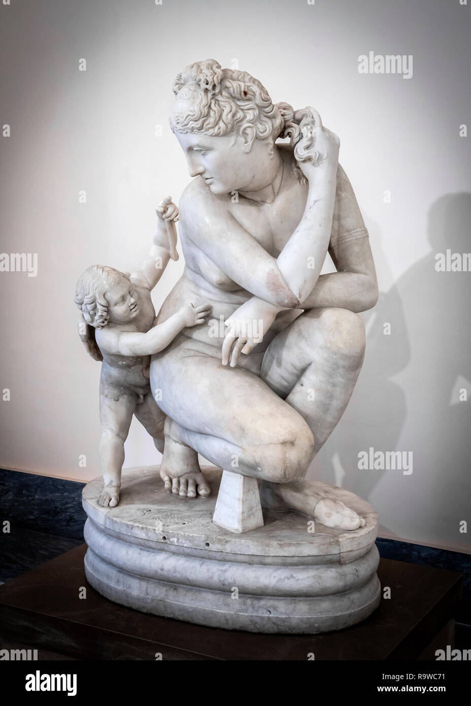 A marble sculpture of a crouching Aphrodite with cupid, 2nd. cen. AD, from a Greek original of the Hellenistic period.  In the National Archaeological Stock Photo
