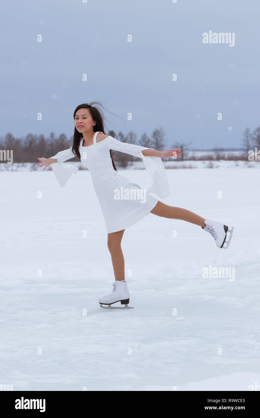 Beautiful young woman on skates in white dress outdoors at winter snow Stock Photo - Alamy Beautiful young woman on skates in white dress outdoors at winter snow Stock Photo - Alamy