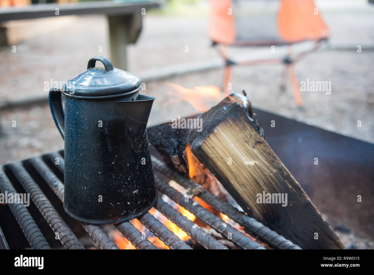 Tea Kettle sitting on an open grill campfire at a campground Stock
