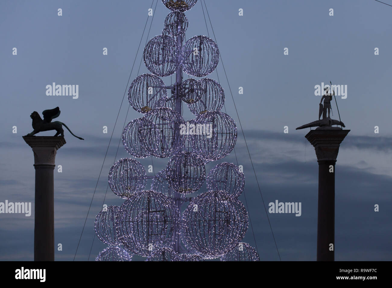 Christmas tree installed between the Column of Saint Mark (Colonna di San Marco) and the Column of Saint Theodore (Colonna di San Todaro) in Piazzetta di San Marco in Venice, Italy. Stock Photo